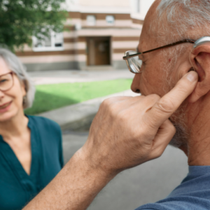 old man pointing to his hearing aid 